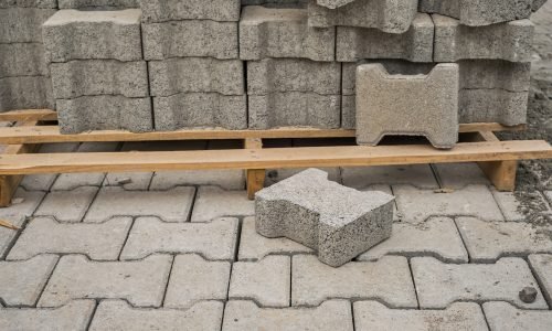 Paving slabs stacked on a pallet, road repair process, close-up, selective focus on tiles, seasonal reconstruction of pavement in walking paths in parks
