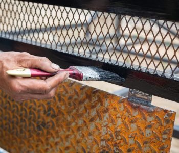 Workers use black steel paint brushes.